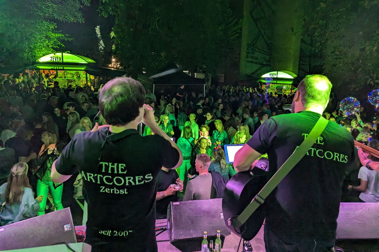 The Artcores von hinten auf der Bühne beim Altstadtfest Jever 2024, vor ihnen ein voller Platz mit Publikum